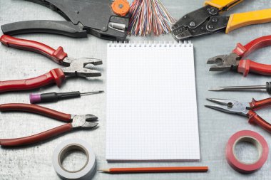 Elektrik araçları, not defteri ve kalem Metalik arka plan üzerinde kümesi. Enerji kavramı. Metin için yer kopyalayın.