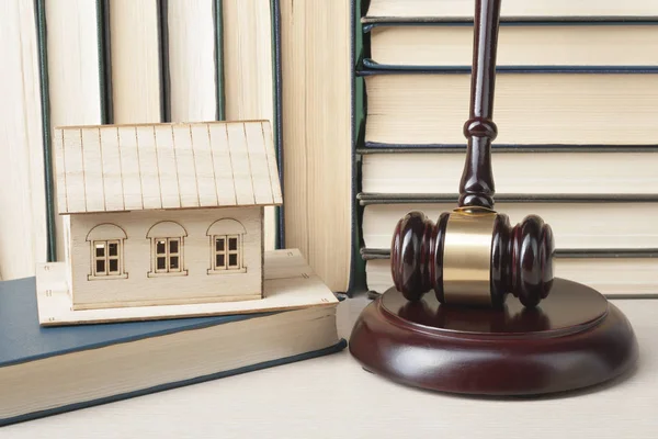 Law concept -Miniature house, books with wooden judges gavel on table in a courtroom or enforcement office.