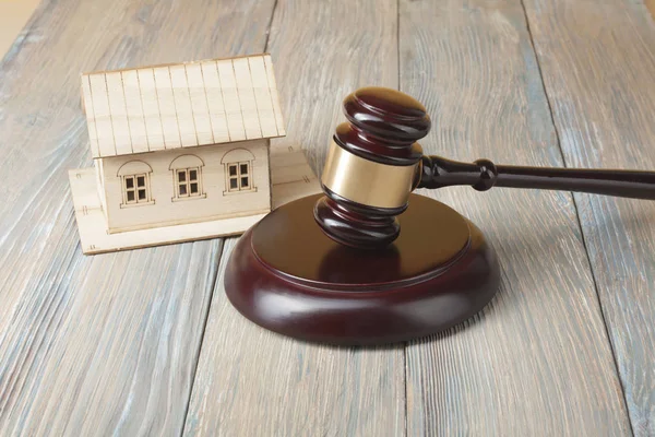 Açık artırma. Hukuk kavramı. Minyatür ev ve masada tahta tokmak