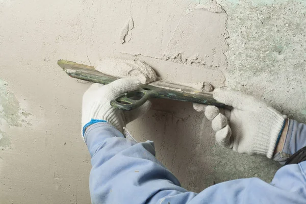 Concepto de construcción y renovación. La mano del hombre en el guante con la paleta durante la reparación de la pared . — Foto de Stock