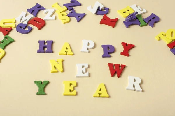 Texte HAPPY NEW YEAR sur fond jaune écrit sur des blocs colorés de l'alphabet. Concept de vacances . — Photo