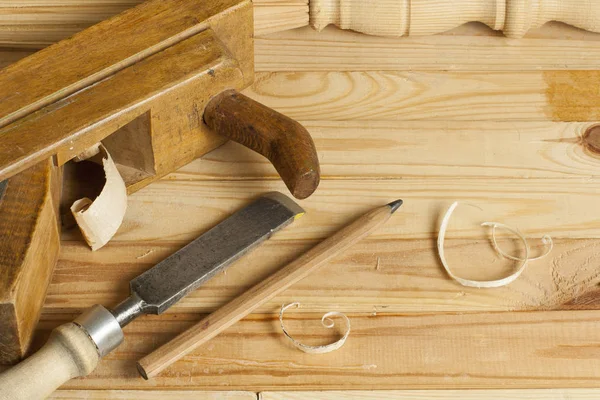 Concepto de carpintería.Empleado carpintero carpintero. Herramientas de construcción sobre mesa de madera con serrín . — Foto de Stock