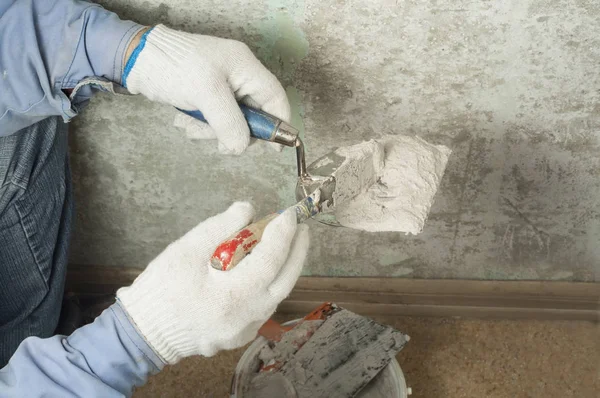 Conceito de construção e renovação. Mãos de trabalhador em luvas com ferramentas de reboco . — Fotografia de Stock