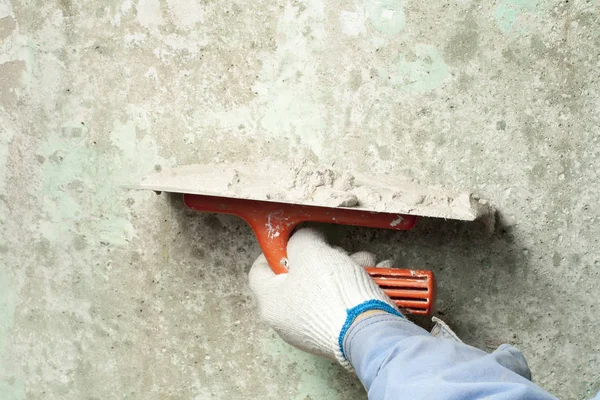 Conceito de construção e renovação. Mão de homem em luva com espátula durante o reparo de parede . — Fotografia de Stock