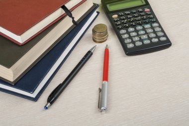 Ev tasarruf, bütçe kavramı. Not Defteri, kalem, hesap makinesi ve sikkeler üzerinde ahşap ofis masaları.
