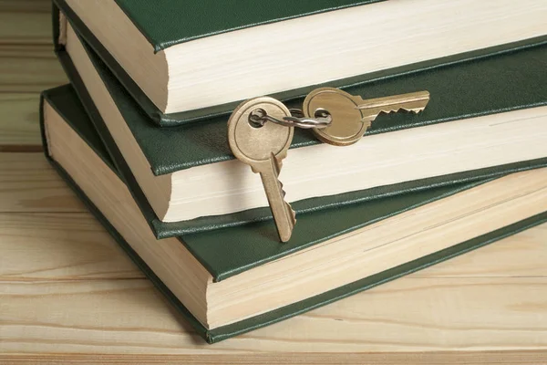 Klíč k poznání. Knihy s klíči na dřevěné pozadí. — Stock fotografie