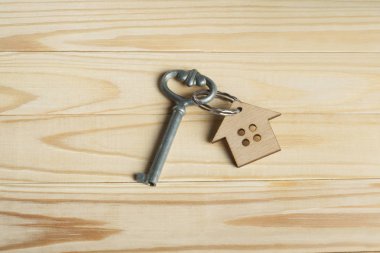 Konsept Emlak veya kiralama özelliği için. Evin anahtarını ve ahşap arka plan üzerinde para ile sembolü.