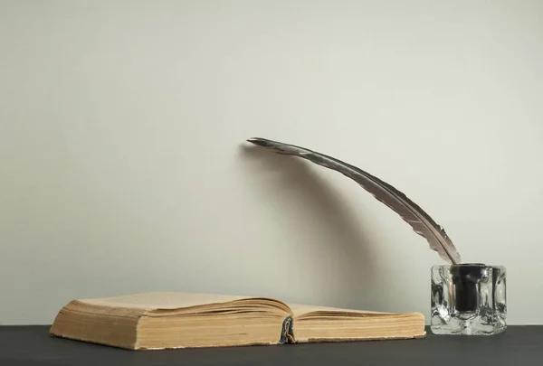 Stare książki i pióro pióro z inkwell na drewnianym stole. Bezpłatny egzemplarz przestrzeni. — Zdjęcie stockowe