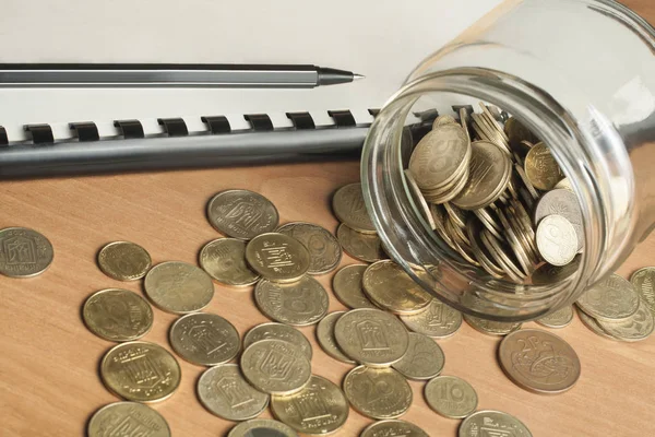 Pojęcie finansów i budżetu. Ksiąg rachunkowych, pióra i szkła słoik z monet na office tabela — Zdjęcie stockowe