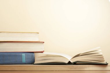 Açık kitap ve ahşap masa üzerinde kitap yığını. Eğitim arka plan. Okula dönüş. Metin için yer kopyalayın.