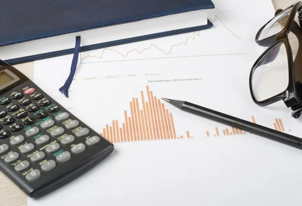 Binnenlandse besparingen, begroting concept. Grafiek, notepad, calculator en glazen op houten kantoor bureau tafel — Stockfoto