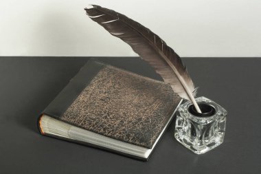 Eski kitap ve tüy kalemle InkWell ahşap masa üzerinde. Ücretsiz kopya alanı.