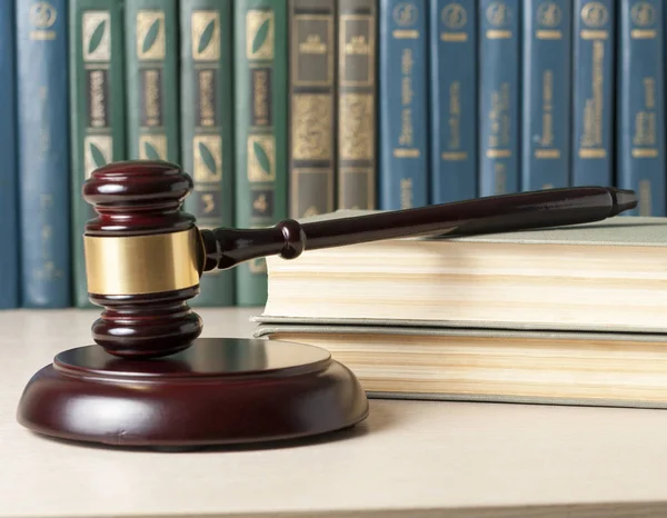 Concepto de ley. Libros con jueces de madera martillo en la mesa en una sala de tribunal u oficina de aplicación de la ley . — Foto de Stock