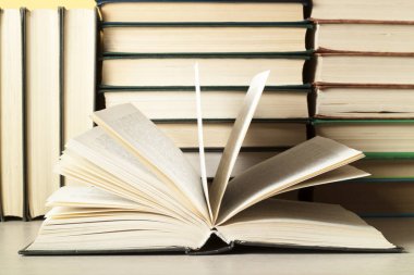 Açık kitap ve ahşap masa üzerinde kitap yığını. Eğitim arka plan. Okula dönüş.