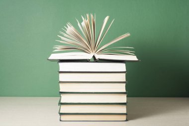 Açık kitap üzerinde ahşap masa üzerinde kitap yığını. Eğitim arka plan. Okula dönüş. Ücretsiz kopya alanı.