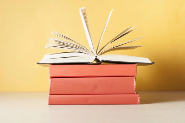 Açık kitap üzerinde ahşap masa üzerinde kitap yığını. Eğitim arka plan. Okula dönüş. Ücretsiz kopya alanı.