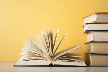 Açık kitap üzerinde ahşap masa üzerinde kitap yığını. Eğitim arka plan. Okula dönüş. Ücretsiz kopya alanı.