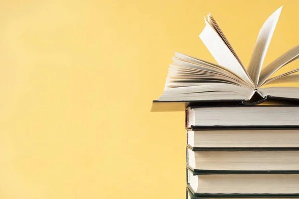 Açık kitap üzerinde ahşap masa üzerinde kitap yığını. Eğitim arka plan. Okula dönüş. Ücretsiz kopya alanı.