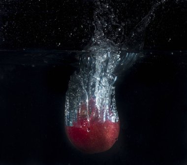 Kırmızı elma kabarcıkları ile suda sıçraması