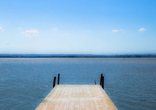 Dermaga kayu di laguna indah di bawah langit biru di Puglia (Italia ) — Stok Foto