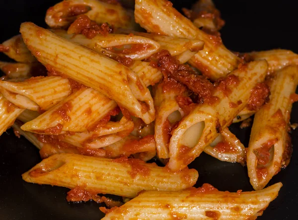 Comida italiana - Penne al 'arrabbiata (Canetas irritadas), uma receita clássica de massas italiana com molho de tomate picante, pimentas vermelhas e salsa . — Fotografia de Stock