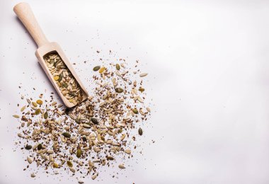 Susam, kabak çekirdeği, Ayçekirdeği, chia tohumu, keten tohumu, haşhaş tohumu ve bir tahta kaşık