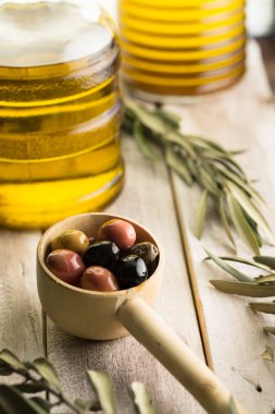 Zeytin, zeytinyağı şişesi ve zeytinyağı yaprakları kadar yakın.