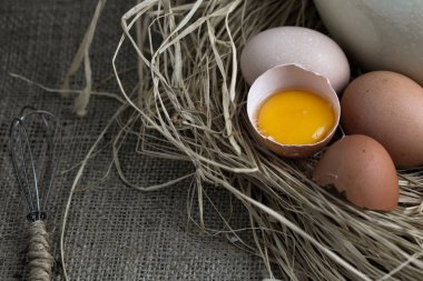 Halk yumurta ve tavuk yumurta saman Nest, sackloth arka plan üzerinde küçük Delme.