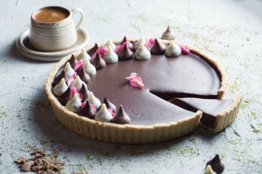 Bir fincan kahveli çikolatalı turta, ahşap masada fotokopi makinesiyle.