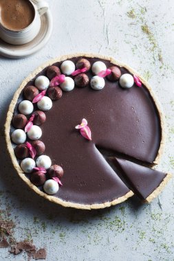 Çikolatalı tart ve boyalı bir fincan kahvenin üst görüntüsü.