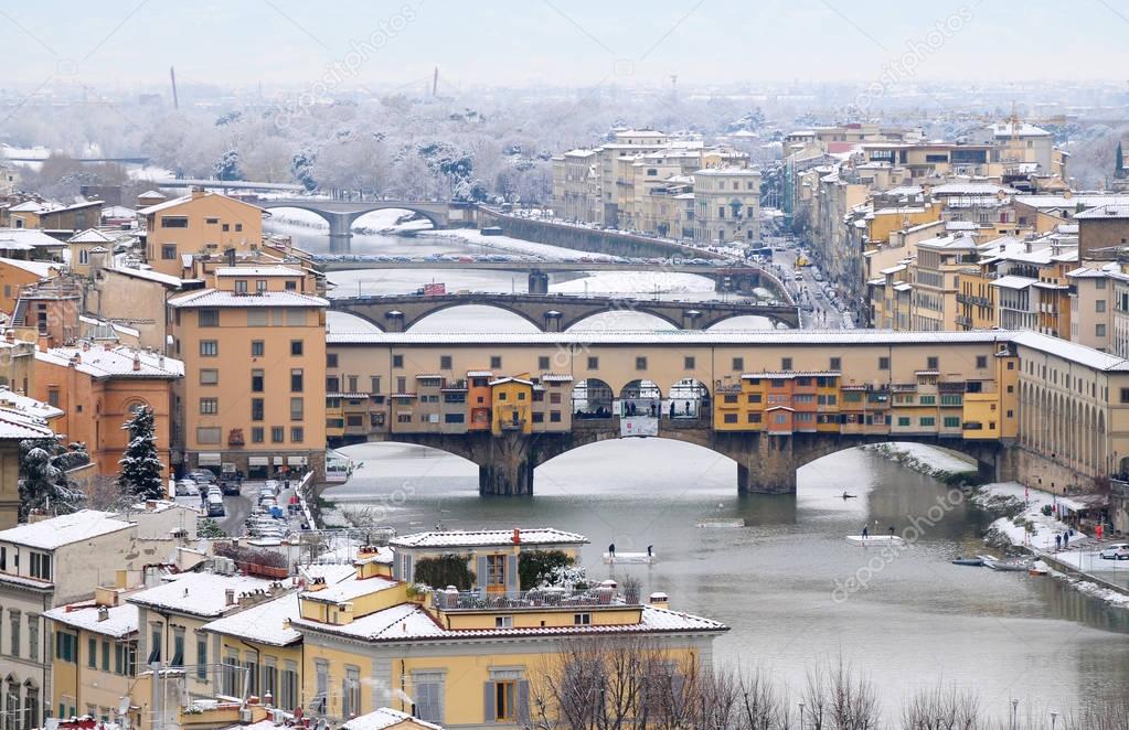 Beautiful view of Ponte Vecchio (Old Bridge) in Florence with snow panorama in Winter. Cityscape. Italy. 