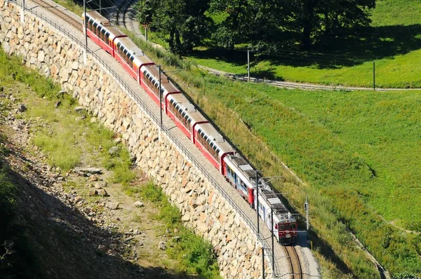 Zwitserland: juli 2012, Zwitserse rode trein Bernina Express doorgeven Brusio Viaduct, Italië & Zwitserland — Stockfoto