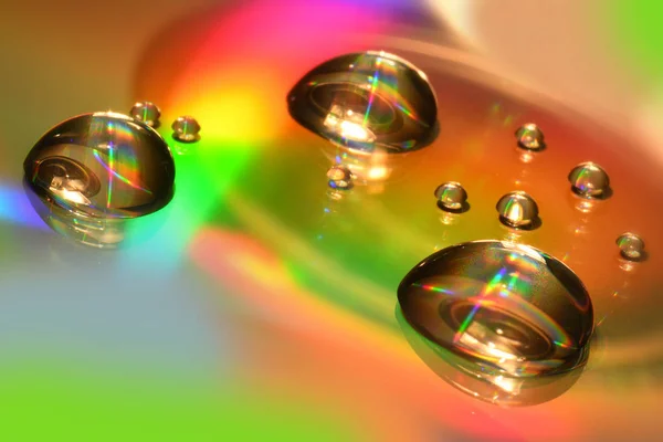 Water Drops sur CD et DVD. Fond coloré . — Photo
