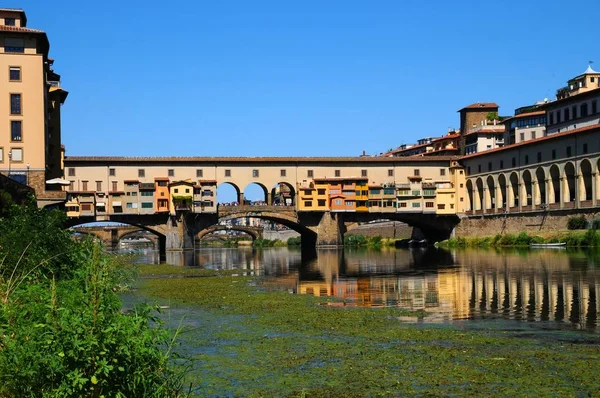 15 augustus 2017: een mooi uitzicht op de beroemde oude brug (Ponte Vecchio) en de Uffizi galerie met blauwe hemel in Florence gezien vanaf de rivier Arno, Italië. — Stockfoto