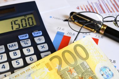 Hesap makinesi, kalem, gözlük ve evrak ile Euro banknot. İşletme kavramı resmi.