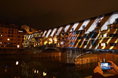 İtalya, Floransa, Aralık 2019: Floransa 'nın Meşhur Eski Köprüsü (Ponte Vecchio), 2019 yılbaşı sezonunda Ay Işığı Firenze Işık Festivali' nde aydınlandı. İtalya