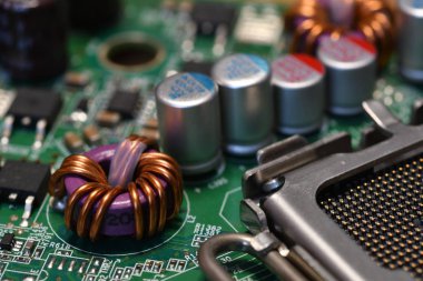 Modern bir bilgisayar anakartının elektronik bileşenlerindeki aşırı detay. Kondansatörler, direnç ve ön plandaki diğer bileşenler. Seçici Odaklanma.