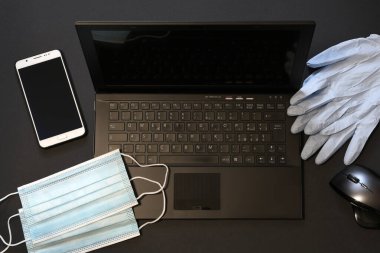 Coronavirus için cerrahi maske, fare, akıllı telefon ve eldivenli klavyede covid-19 koruması. İş, evde kalmak. akıllı çalışma kavramı.