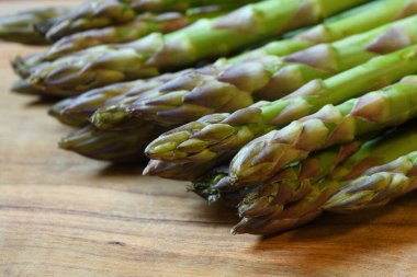 Kuşkonmaz, zeytin ağacının arka planında taze kuşkonmaz. Tahtada taze kuşkonmaz.