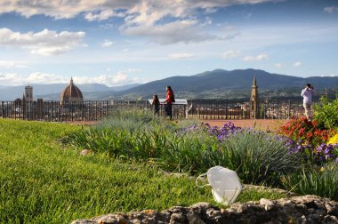 Floransa, Mayıs 2020: Coronavirus pandemik döneminde Santa Maria del Fiore Katedrali 'ne hayran olan turistler ve Piazzale Michelangelo' daki bahçelerdeki çimlerde bulunan tıbbi maske türü ffp2 veya KN95. İtalya