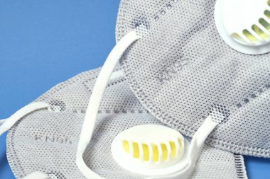 Mavi arka planda, ffp2 ya da KN95 antivirüs korumalarının ayrıntıları. Coronavirus veya COVID-19 ve SARS enfeksiyonunu önleme.