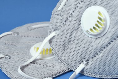 Mavi arka planda, ffp2 ya da KN95 antivirüs korumalarının ayrıntıları. Coronavirus veya COVID-19 ve SARS enfeksiyonunu önleme.