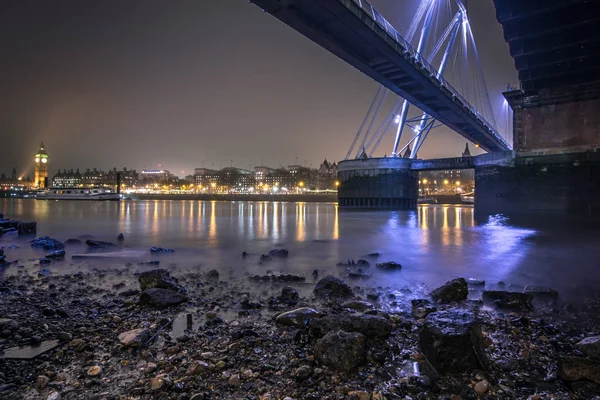 Puente del Jubileo de Oro y paisaje urbano de Londres visto desde la playa del Támesis en marea baja — Foto de Stock