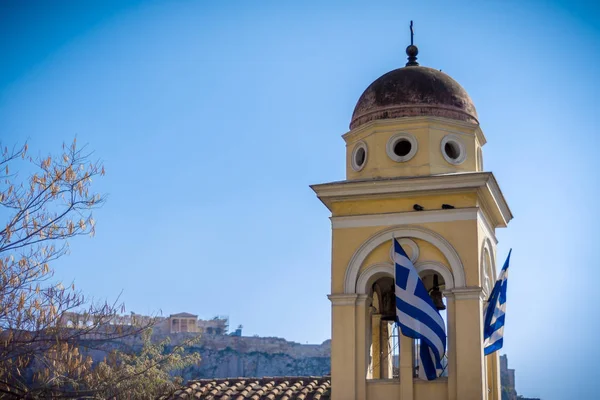 Detalle de la iglesia ortodoxa griega con banderas griegas y acrópolis y partenón en el fondo . — Foto de Stock