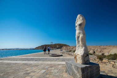 Naxos, Yunanistan - 12 Temmuz 2019: Turistler Ariadne heykelinin yanından geçerek Portara, Apollo tapınağına giden yolda yürüyorlar
