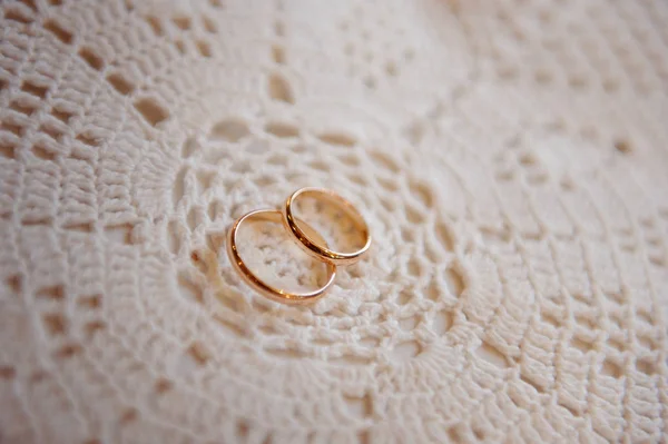 Wedding rings on a white lace napkin — Stock Photo, Image