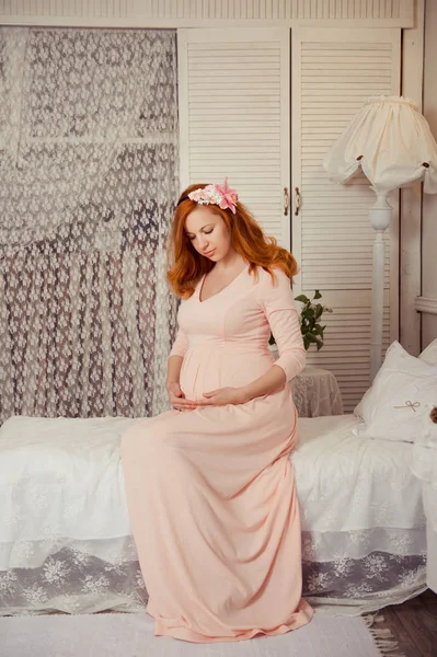 Mulher grávida com cabelo vermelho em vestido rosa — Fotografia de Stock