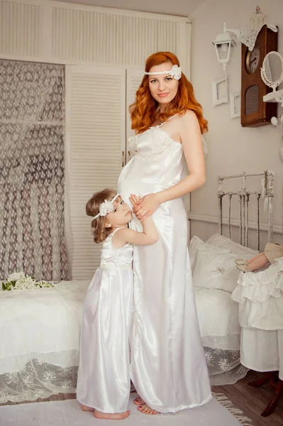 Mãe e filha em roupas brancas idênticas. Mulher grávida . — Fotografia de Stock