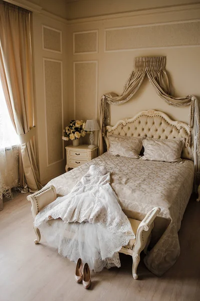 El vestido de novia está en la habitación de la cama. Zapatos de boda beige —  Fotos de Stock