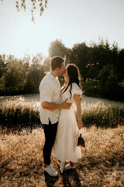 Junges Paar Spaziert Und Küsst Sich Auf Sommerwiese Bei Sonnenuntergang — Stockfoto